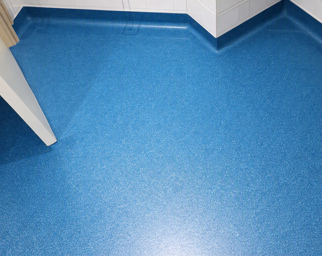 Blue cap-and-cove safety vinyl flooring installation
