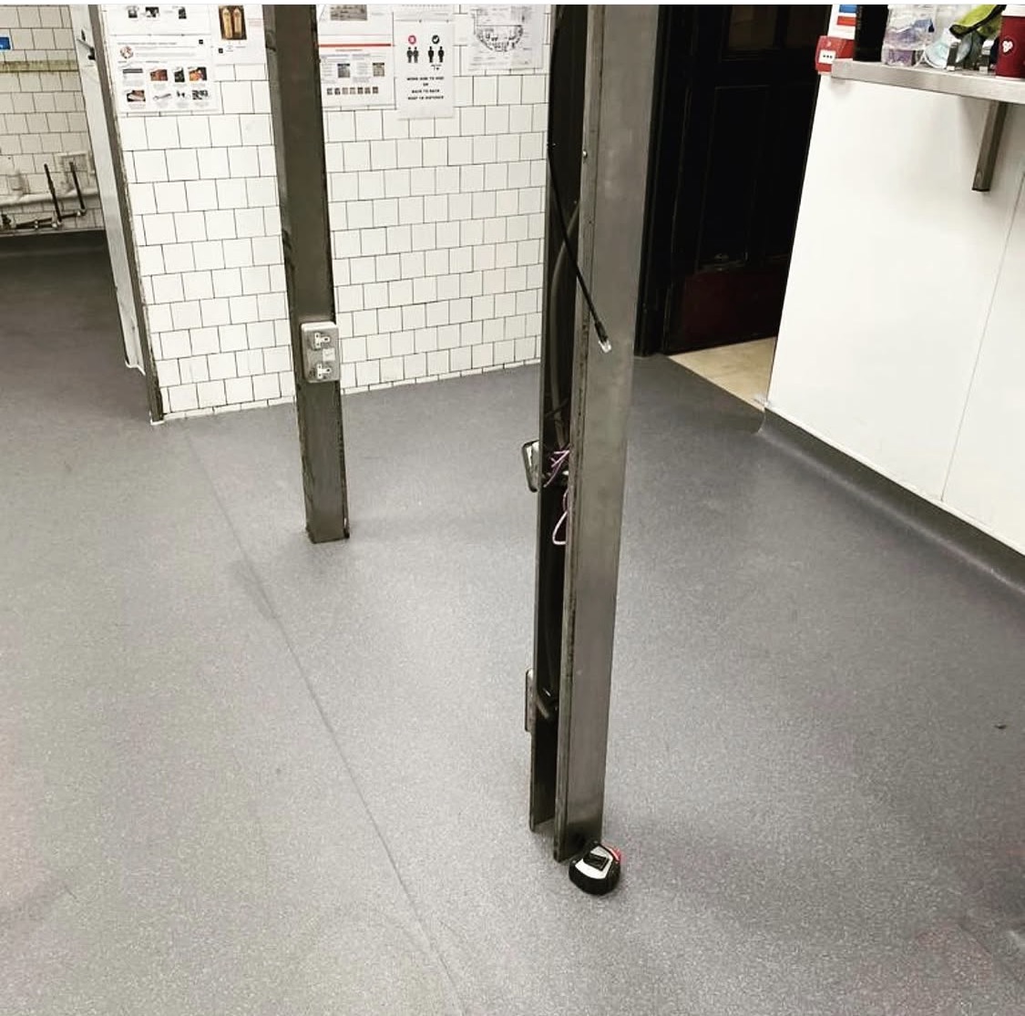 Wider view of the installed grey safety floor around the kitchen supports, before equipment reinstatement