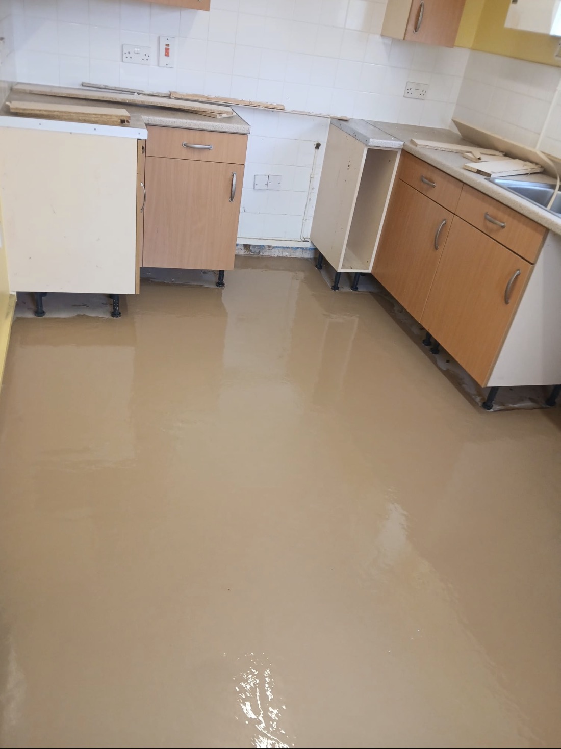Levelling compound applied across the kitchen floor